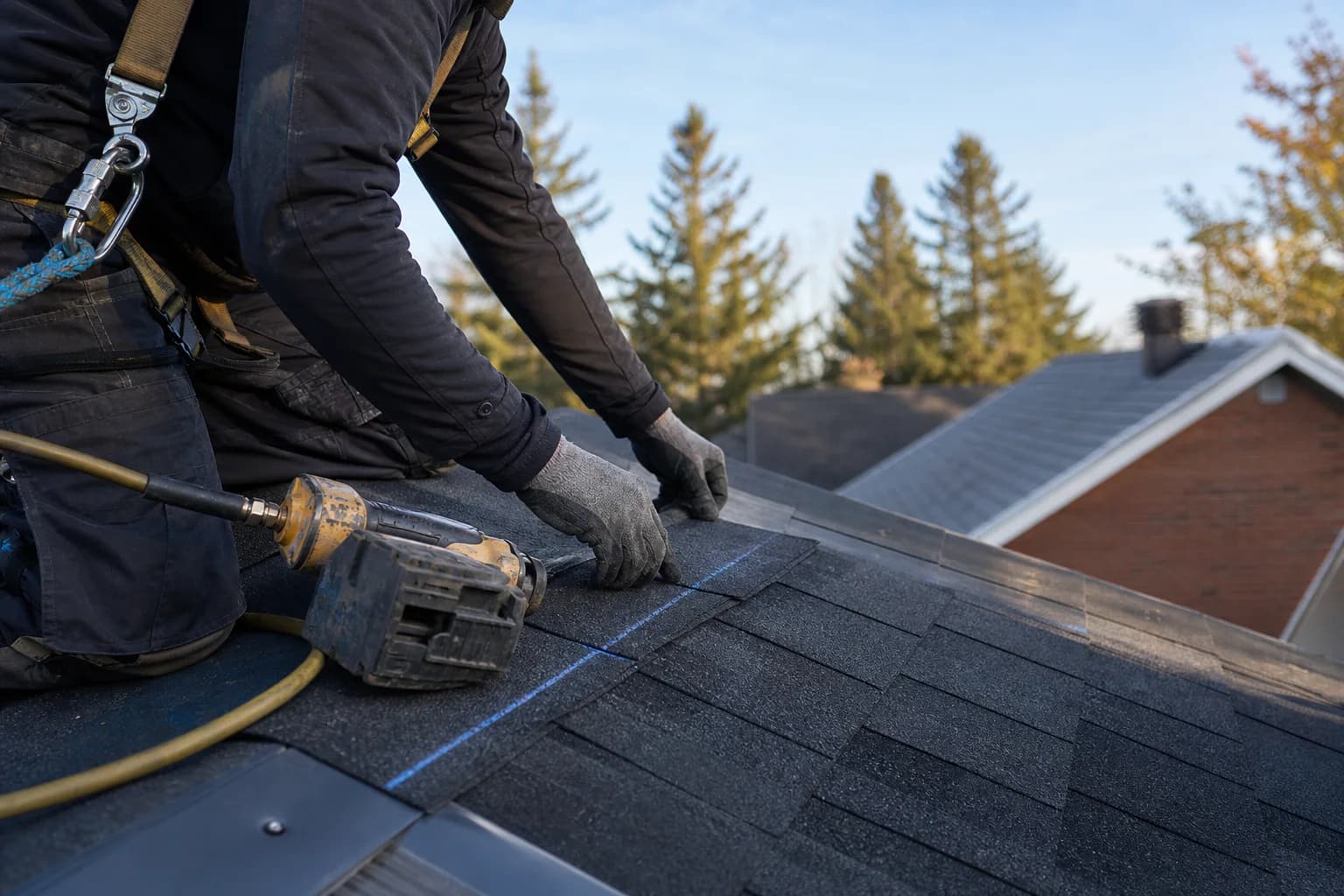 Representative image of an Ottawa roofer installing asphalt shingles with safety equipment